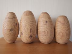 four wooden eggs lined up on a table