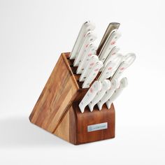 a set of knives sitting on top of a wooden block in front of a white background