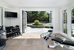 there is a gym with exercise equipment in the room and an open door leading to another area