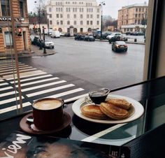 two plates of food on a table near a window