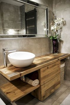 a bathroom with a sink, mirror and towel rack in front of the counter top