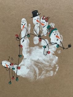 an image of snowmen with hats and lights on their hands painted on brown paper