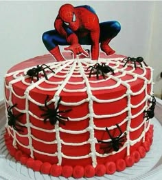 a spiderman cake is decorated with red icing