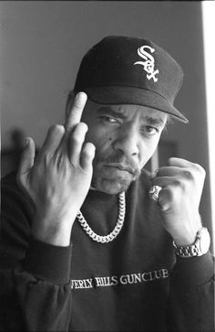 a black and white photo of a man wearing a chicago white sox baseball cap holding his finger up