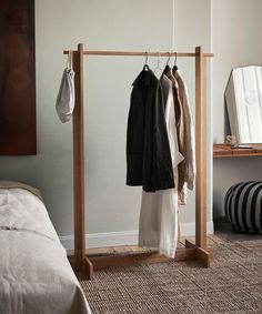 a clothes rack with two coats hanging on it