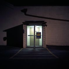 an open door to a building at night with the light on and no one in it