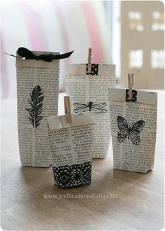 three small bags with clothes pins attached to them on a table next to some books