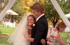 a bride and groom hugging each other under a gazebo