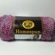 a pink and purple yarn ball on a white surface with the words homespun printed on it