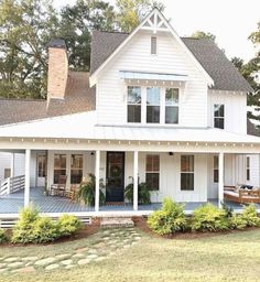 a large white house sitting on top of a lush green field