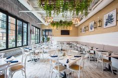 an empty restaurant with white tables and chairs