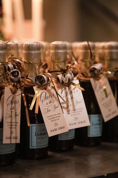 several bottles of wine are lined up on a table with tags attached to the bottles