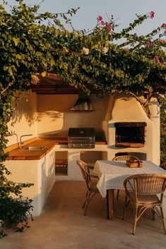 an outdoor kitchen with table and chairs