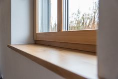 an empty window sill in front of a white wall with wood trim and windowsill