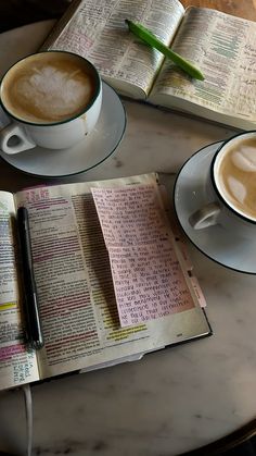 two cups of coffee and an open book on a table