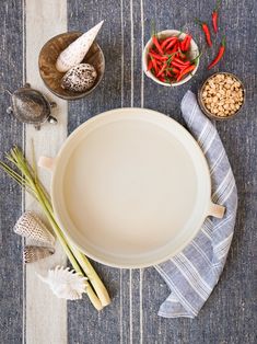 an empty bowl on a table next to other dishes