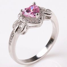 a pink heart shaped diamond ring with diamonds around it