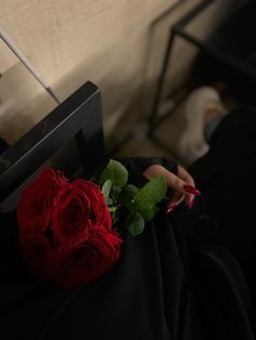 a red rose sitting on top of a black chair