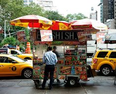 a man standing in front of a food cart