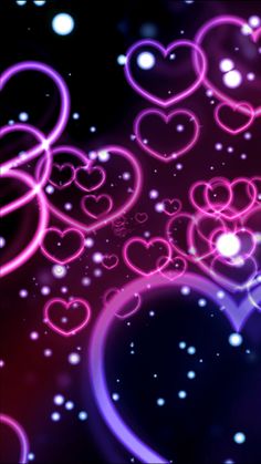 many hearts are floating in the air on a black background with pink and purple lights