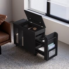 an open laptop computer sitting on top of a black desk next to a brown chair