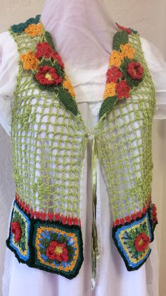 a crocheted vest with flowers on it