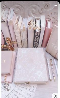 there are many different types of notebooks and pens on the table, including one in pink