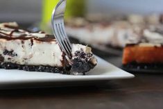 a piece of cheesecake on a white plate with a fork stuck in the cake