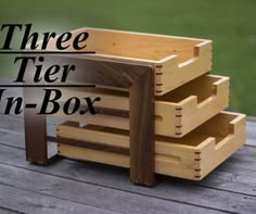 the three tier in - box is made out of wood and sits on a wooden deck