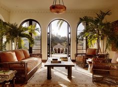 a living room filled with lots of furniture and large arched windows next to each other