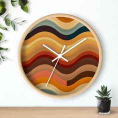 a clock with an abstract design on the face next to a potted green plant