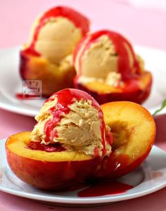 two white plates topped with peaches covered in ice cream