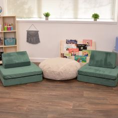 two green chairs and a round ottoman in a child's room