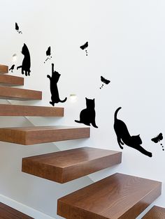 several cats are sitting on the stairs and flying around