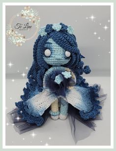 a crocheted doll sitting on top of a white and blue surface with stars in the background