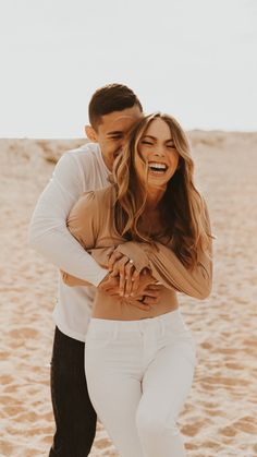 a man and woman hugging on the beach