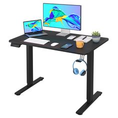 a computer desk with two monitors, headphones and a plant on top of it