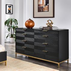 a bedroom with a dresser, mirror and potted plant on the side table in front of it