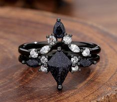 a black diamond ring sitting on top of a wooden table