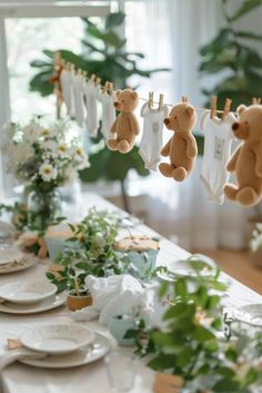 the table is set with teddy bears and baby clothes hanging from it's line