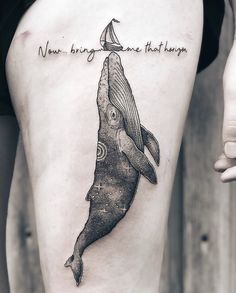 a woman's thigh with a whale tattoo on it