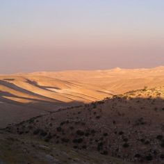 the sun shines on some hills in the desert