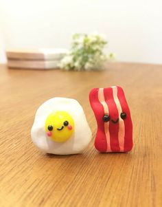 two small toy eggs sitting on top of a wooden table