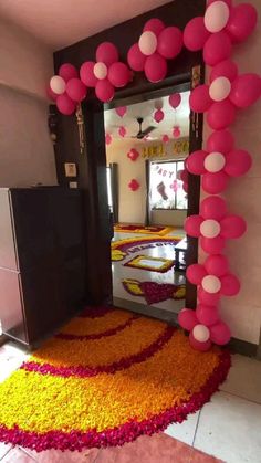 the entrance to a room decorated with flowers and balloons in pink, yellow and white colors