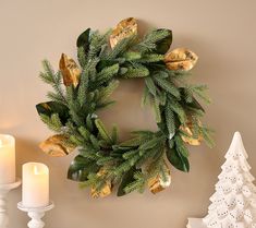 a wreath on the wall next to candles