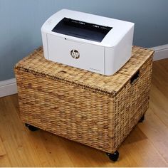 a white printer sitting on top of a wicker basket