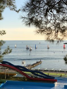 there are many sailboats in the water and one is on top of a ramp