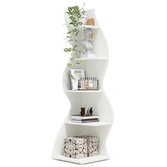 a white shelf with some plants and books on it