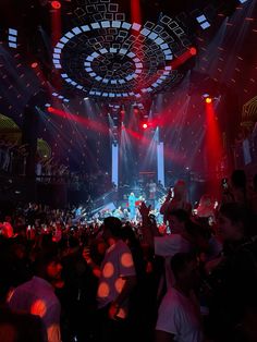 a large group of people in a room with red and white lights