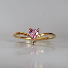 This 14K Pink Sapphire Heart ring makes for a perfect promise ring, or as a gift for your beloved. Nothing like saying "I love you" with this dainty beauty top with a natural white diamond. Perfect to wear alone or stacked with other ring bands. Available in 14k yellow gold, rose gold, and white gold. Pair it with our Siren Marquise ring or Winter Palace Marquise ring (as pictured) for the ultimate majestic look. This ring is designed and made in NYC. 14k solid gold band Natural pink heart sapph Sapphire Heart Ring, Sapphire Ring Designs, Pink Sapphire Diamond Ring, Cute Promise Rings, Heart Promise Rings, Ring Bands, Cute Engagement Rings, Solid Gold Band, Sapphire Diamond Ring